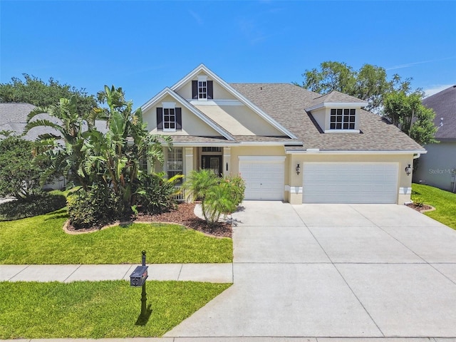 craftsman inspired home with a garage, a front lawn, concrete driveway, a shingled roof, and stucco siding