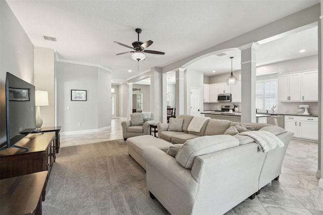 living room with visible vents, decorative columns, recessed lighting, arched walkways, and a ceiling fan