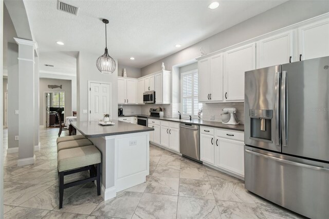 kitchen with visible vents, dark countertops, appliances with stainless steel finishes, marble finish floor, and white cabinetry