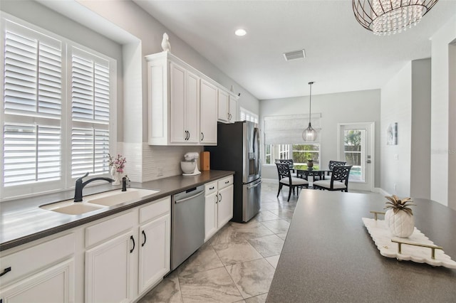 kitchen with visible vents, marble finish floor, dark countertops, a sink, and appliances with stainless steel finishes