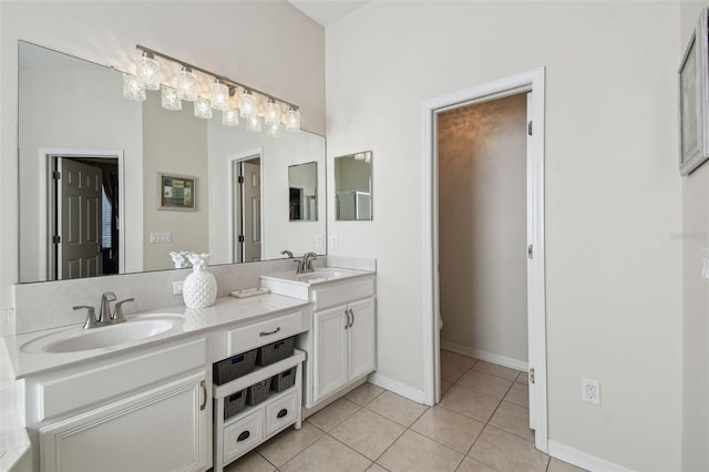 bathroom featuring tile patterned flooring, a sink, baseboards, and double vanity