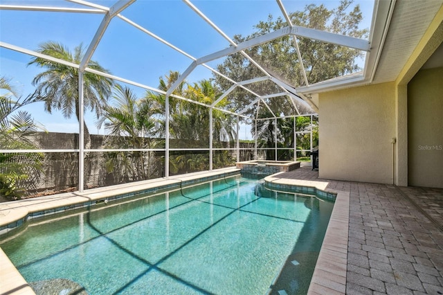 view of swimming pool with a patio, glass enclosure, and a pool with connected hot tub