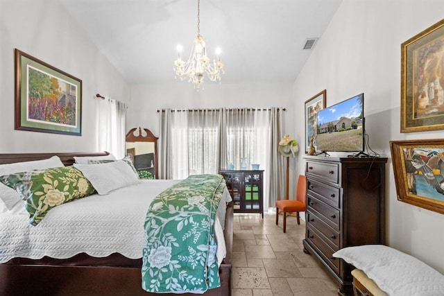 bedroom featuring stone tile floors, visible vents, and an inviting chandelier