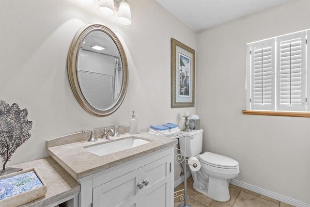 bathroom featuring tile patterned floors, baseboards, vanity, and toilet
