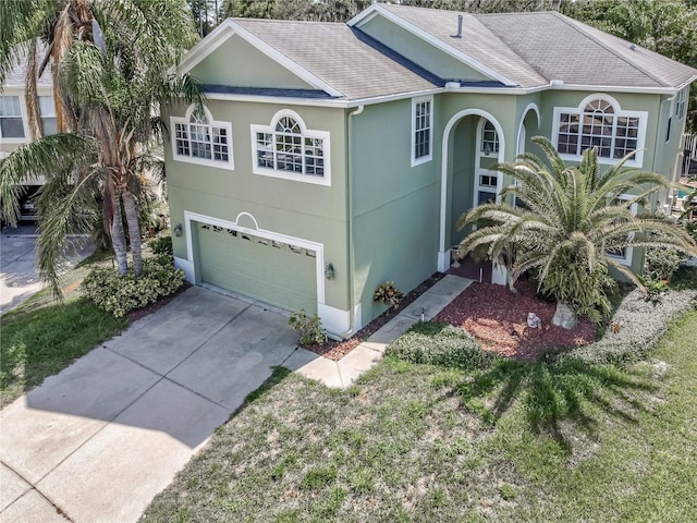 11102 Avery Oaks Dr, Tampa, FL 33625 - view of front facade with an attached garage, a shingled roof, driveway, and stucco siding