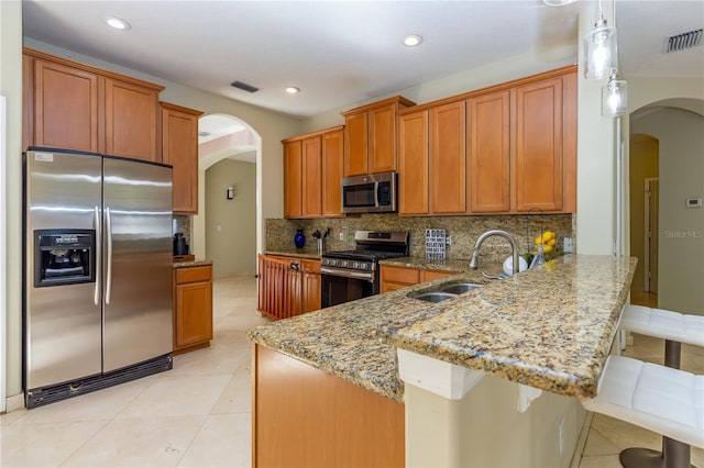 11102 Avery Oaks Dr, Tampa, FL 33625 - kitchen with stainless steel appliances, visible vents, a sink, arched walkways, and a peninsula
