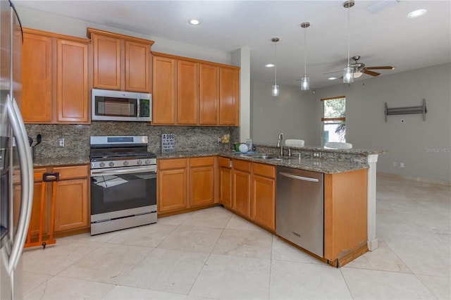 11102 Avery Oaks Dr, Tampa, FL 33625 - kitchen featuring stainless steel appliances, backsplash, a sink, brown cabinetry, and ceiling fan