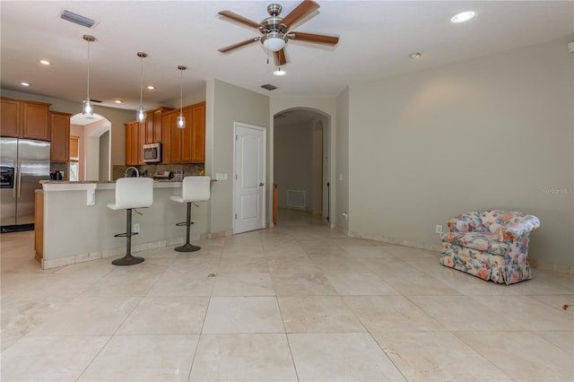 11102 Avery Oaks Dr, Tampa, FL 33625 - kitchen with brown cabinets, arched walkways, appliances with stainless steel finishes, and visible vents