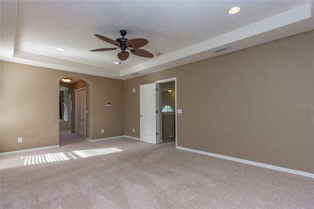 11102 Avery Oaks Dr, Tampa, FL 33625 - unfurnished room featuring light carpet, arched walkways, baseboards, a ceiling fan, and a raised ceiling