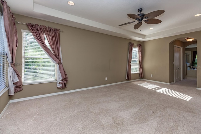 11102 Avery Oaks Dr, Tampa, FL 33625 - unfurnished room with a raised ceiling, a ceiling fan, arched walkways, baseboards, and light colored carpet