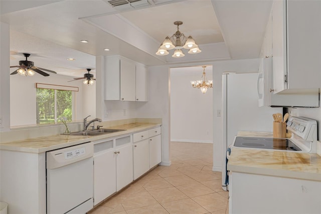 1144 Lanyard St, Palm Harbor, FL 34685 - kitchen featuring a sink, a raised ceiling, white cabinets, light countertops, and white appliances