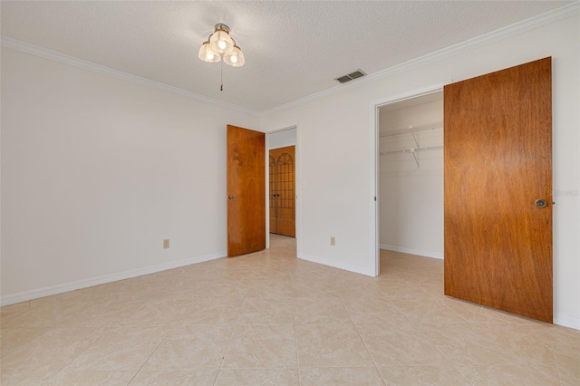 1144 Lanyard St, Palm Harbor, FL 34685 - unfurnished bedroom featuring crown molding, a textured ceiling, a spacious closet, visible vents, and a closet