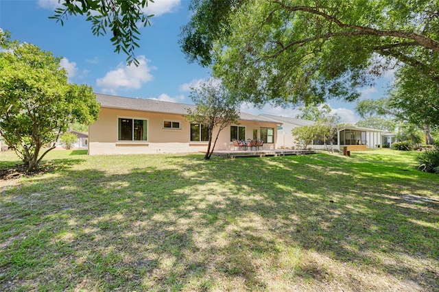 1144 Lanyard St, Palm Harbor, FL 34685 - back of house with a yard, a sunroom, and stucco siding
