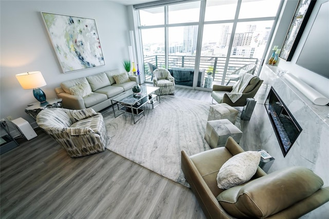 living area featuring a city view, expansive windows, and wood finished floors