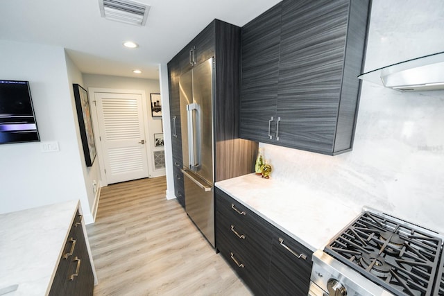 kitchen with dark cabinetry, light countertops, visible vents, and light wood-style floors