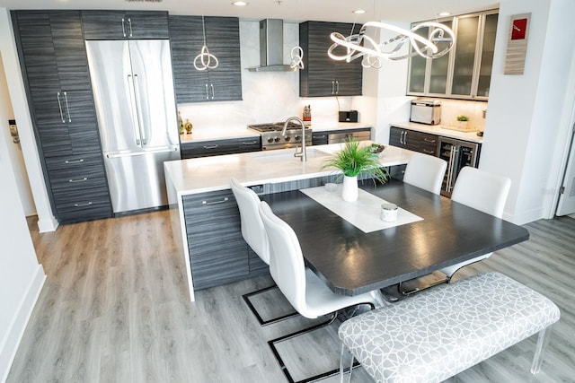 dining room featuring light wood finished floors, recessed lighting, baseboards, and a notable chandelier