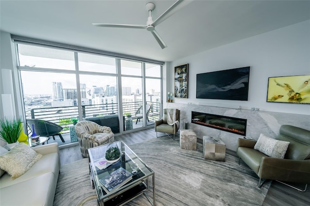 living area featuring floor to ceiling windows, a wealth of natural light, wood finished floors, and ceiling fan