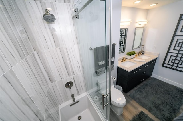 bathroom with toilet, a shower, baseboards, and vanity