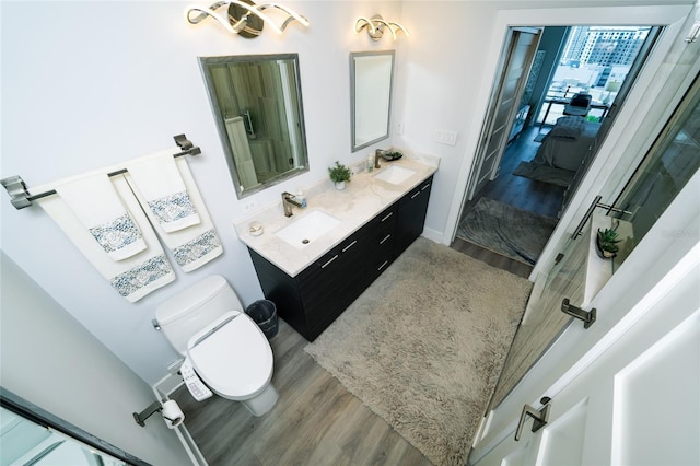 bathroom with a sink, toilet, connected bathroom, and wood finished floors