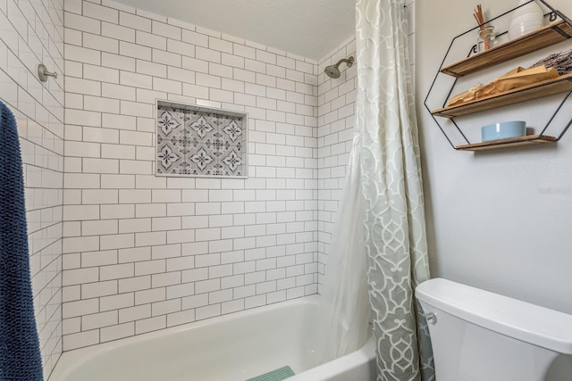 bathroom featuring shower / tub combo and toilet