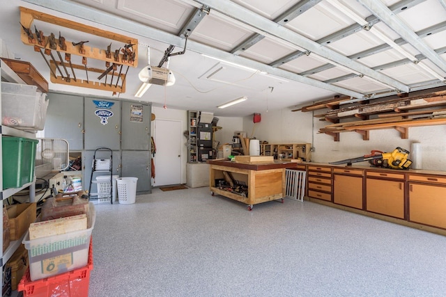 garage with heating unit, a workshop area, and a garage door opener