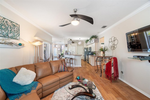 708 Sandy Hills Ave, Tarpon Springs, FL 34689 - living room with a ceiling fan, light wood-style flooring, and crown molding