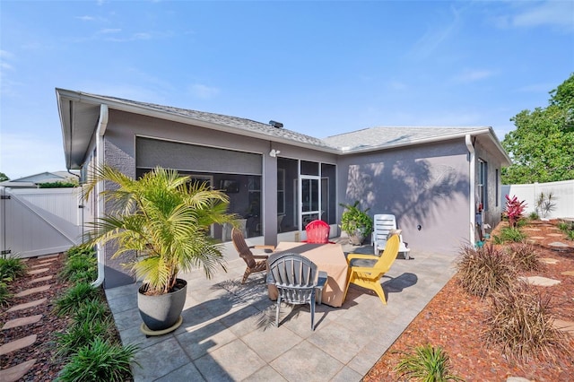 708 Sandy Hills Ave, Tarpon Springs, FL 34689 - rear view of property with a sunroom, a gate, a patio, and stucco siding
