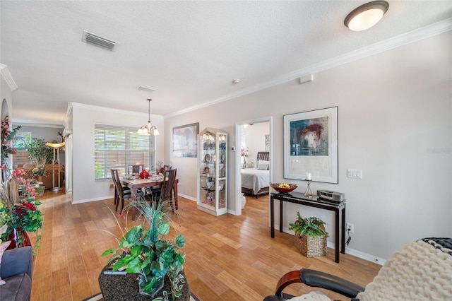 708 Sandy Hills Ave, Tarpon Springs, FL 34689 - living area featuring ornamental molding, light wood-style floors, and a chandelier