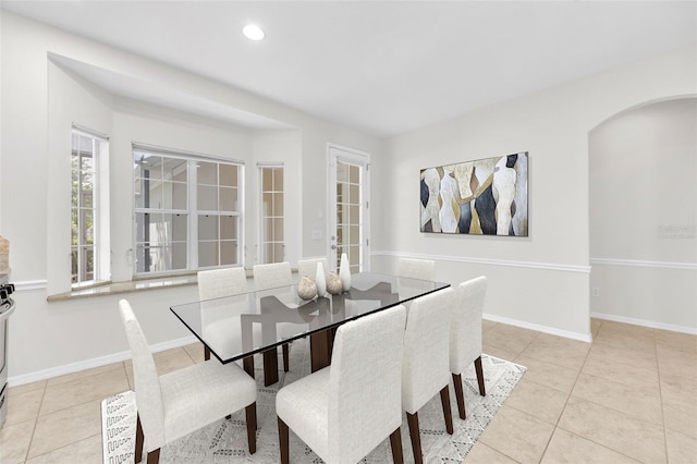 dining space featuring recessed lighting, arched walkways, baseboards, and tile patterned floors