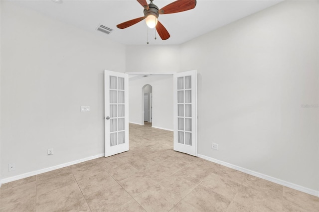 unfurnished room with ceiling fan, arched walkways, french doors, baseboards, and visible vents