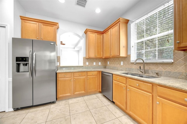 kitchen featuring appliances with stainless steel finishes, a sink, visible vents, and tasteful backsplash
