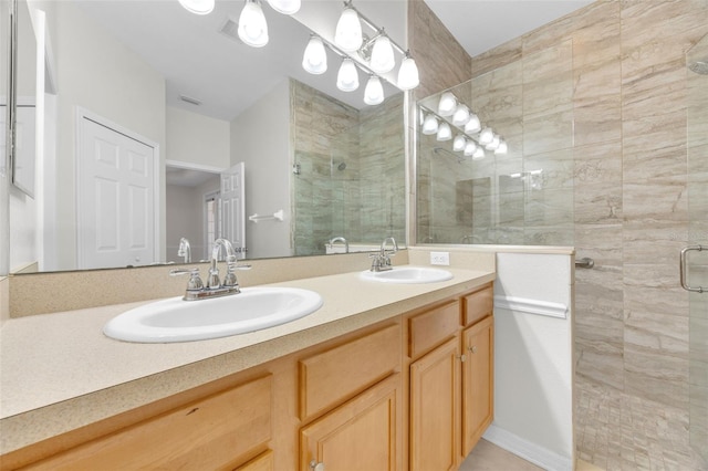 bathroom with a sink, a stall shower, and double vanity