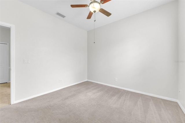 empty room with carpet floors, ceiling fan, and visible vents