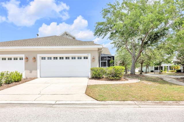 view of front of house with a garage, stucco siding, concrete driveway, and a front yard