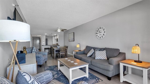 13720 Gulf Blvd Unit 305, Madeira Beach, FL 33708 - living area featuring a textured ceiling, a ceiling fan, and wood finished floors