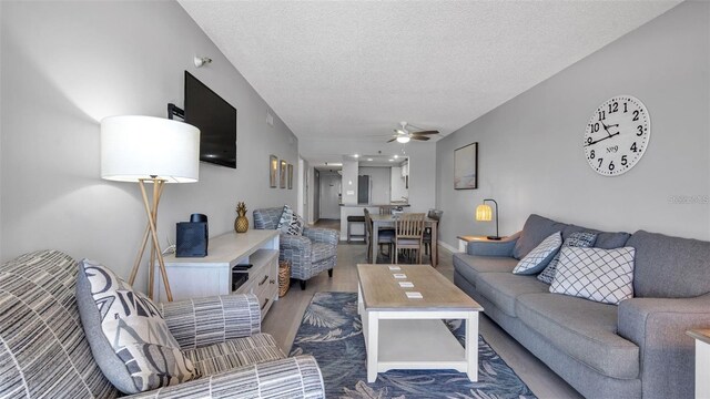13720 Gulf Blvd Unit 305, Madeira Beach, FL 33708 - living area featuring baseboards, wood finished floors, a ceiling fan, and a textured ceiling