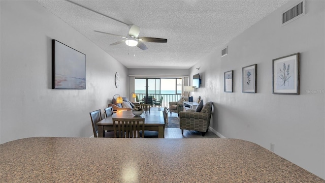13720 Gulf Blvd Unit 305, Madeira Beach, FL 33708 - dining room featuring visible vents, a ceiling fan, and a textured ceiling