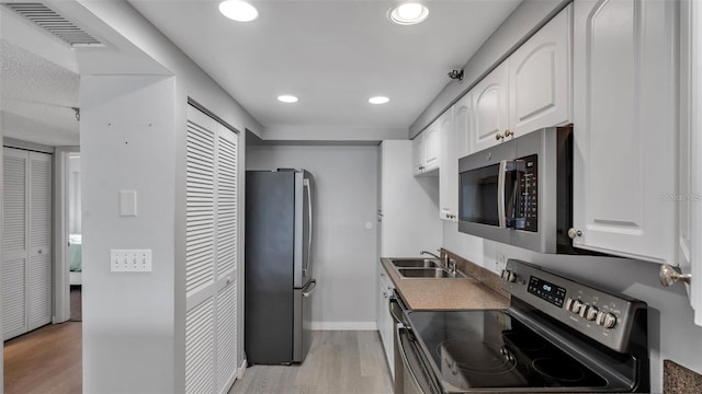 13720 Gulf Blvd Unit 305, Madeira Beach, FL 33708 - kitchen with appliances with stainless steel finishes, visible vents, light wood-style floors, and a sink