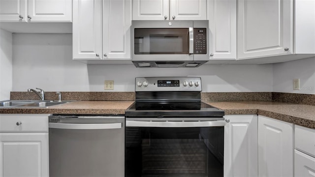 13720 Gulf Blvd Unit 305, Madeira Beach, FL 33708 - kitchen featuring dark countertops, white cabinetry, stainless steel appliances, and a sink