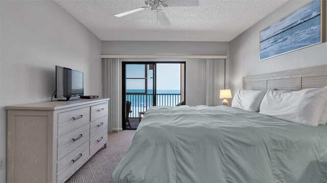 13720 Gulf Blvd Unit 305, Madeira Beach, FL 33708 - bedroom with access to exterior, a ceiling fan, light carpet, and a textured ceiling