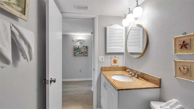 13720 Gulf Blvd Unit 305, Madeira Beach, FL 33708 - bathroom featuring visible vents, baseboards, toilet, wood finished floors, and vanity