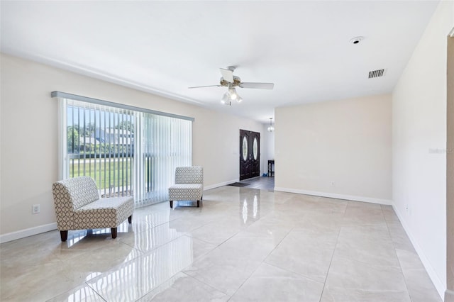 sitting room with baseboards, a ceiling fan, and visible vents