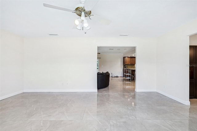 empty room with a ceiling fan, baseboards, visible vents, and marble finish floor