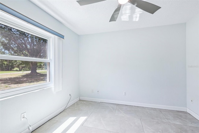 empty room with baseboards, a textured ceiling, and ceiling fan
