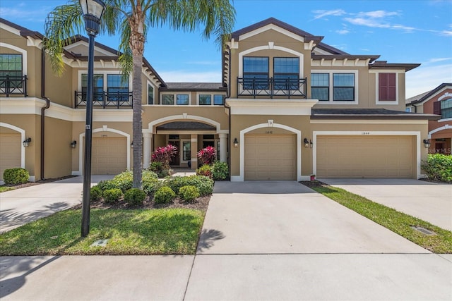 11442 Crowned Sparrow Ln, Tampa, FL 33626 - view of front of house with an attached garage, driveway, stucco siding, and a balcony