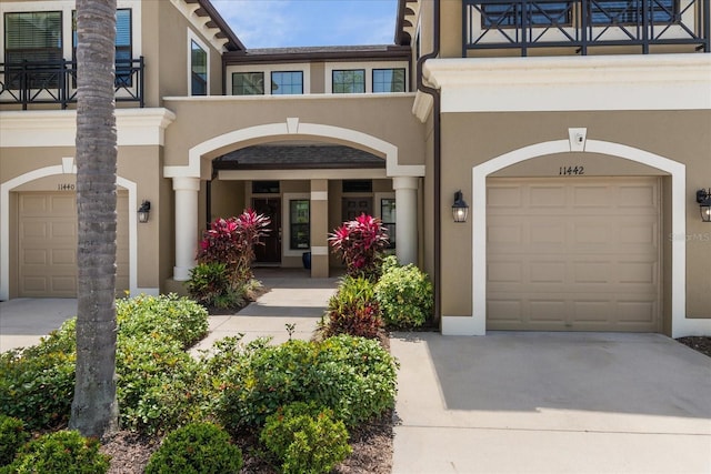 11442 Crowned Sparrow Ln, Tampa, FL 33626 - view of exterior entry featuring stucco siding, driveway, and a balcony