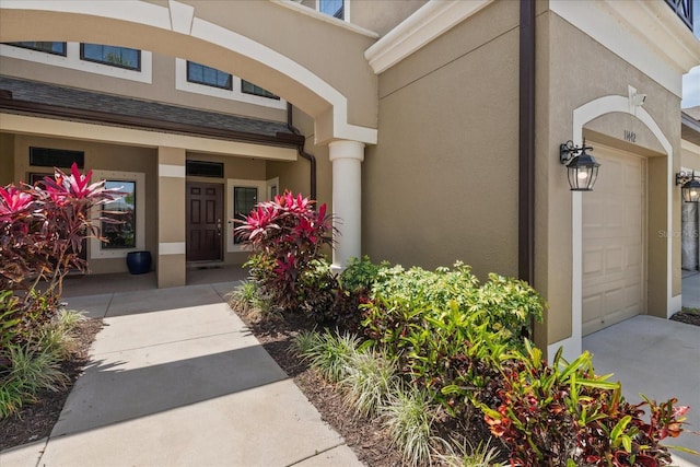 11442 Crowned Sparrow Ln, Tampa, FL 33626 - entrance to property featuring stucco siding, driveway, a porch, and an attached garage
