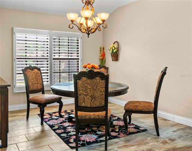 dining space featuring baseboards and an inviting chandelier