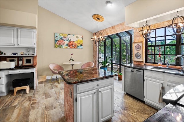 kitchen featuring stainless steel dishwasher, a sink, white cabinets, lofted ceiling, and a notable chandelier