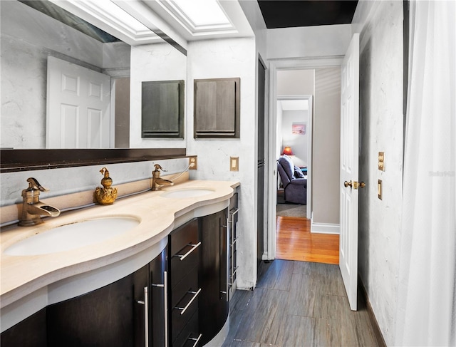 bathroom featuring wood finished floors, a sink, and double vanity